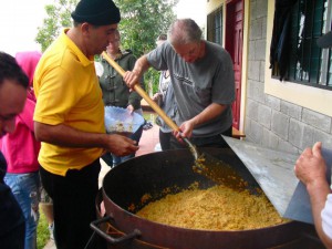 giant pot full of beans and rice being served to people