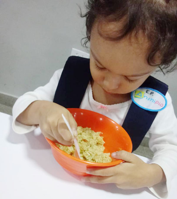 little girl eats from rice bowl