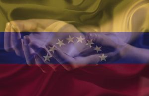 hands being held out with a faded image of the venezela flag