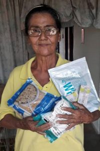 Middle aged woman holding bags of rice