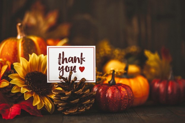 picture of pumpkins and gourds decorating a table with a card that says "thank you"